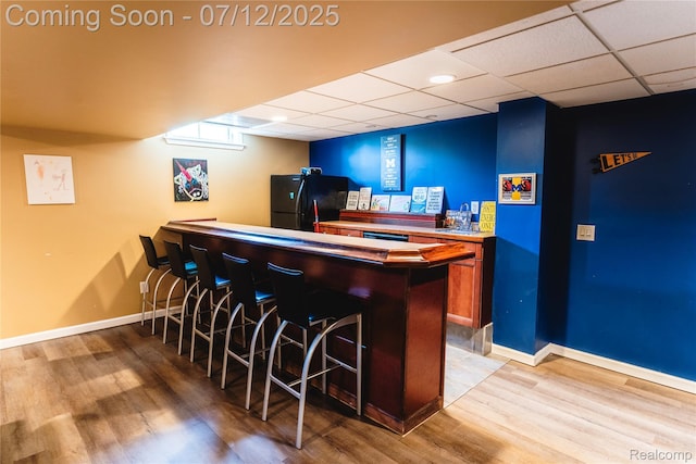 6020 Majestic Oaks Dr, Commerce Twp, MI 48382 - indoor dry bar with freestanding refrigerator, light wood finished floors, and a drop ceiling