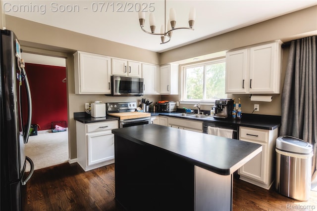 6020 Majestic Oaks Dr, Commerce Twp, MI 48382 - kitchen featuring appliances with stainless steel finishes, dark countertops, a chandelier, and white cabinets