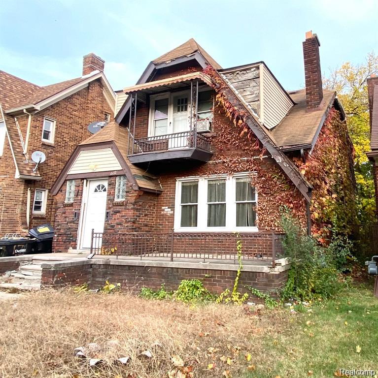 17152 Roselawn St, Detroit, MI 48221 - view of front of home featuring a chimney, brick siding, and a balcony