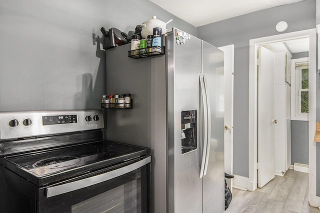 728 Fifth St, Jackson, MI 49203 - kitchen featuring range with electric cooktop, stainless steel fridge, and light wood-type flooring