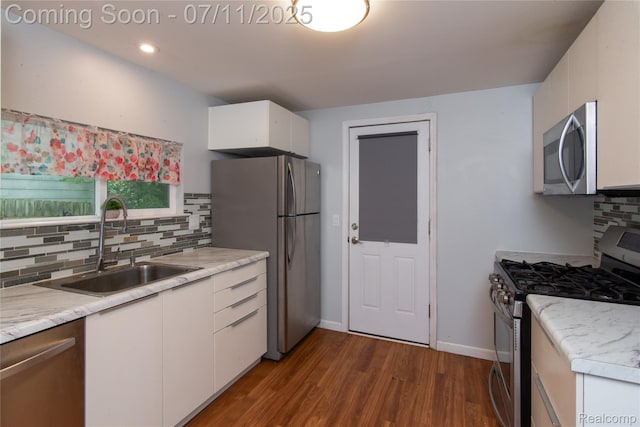 3110 Brisbane St, Walled Lake, MI 48390 - kitchen featuring appliances with stainless steel finishes, dark wood-style floors, white cabinetry, decorative backsplash, and light countertops