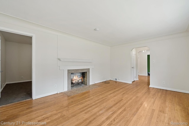 18140 Westover Ave, Southfield, MI 48075 - unfurnished living room featuring a fireplace with flush hearth, wood finished floors, and arched walkways