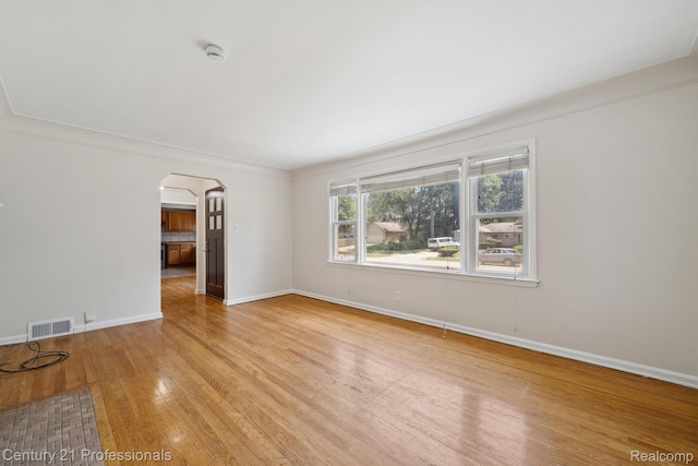 18140 Westover Ave, Southfield, MI 48075 - spare room featuring arched walkways, a smoke detector, and light wood-style floors