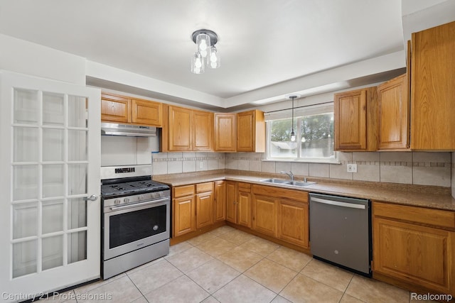 18140 Westover Ave, Southfield, MI 48075 - kitchen with stainless steel appliances, under cabinet range hood, decorative backsplash, and light tile patterned floors