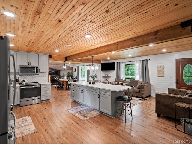 3365 Howland Rd, Almont, MI 48003 - kitchen with stainless steel appliances, open floor plan, gray cabinets, a kitchen breakfast bar, and recessed lighting