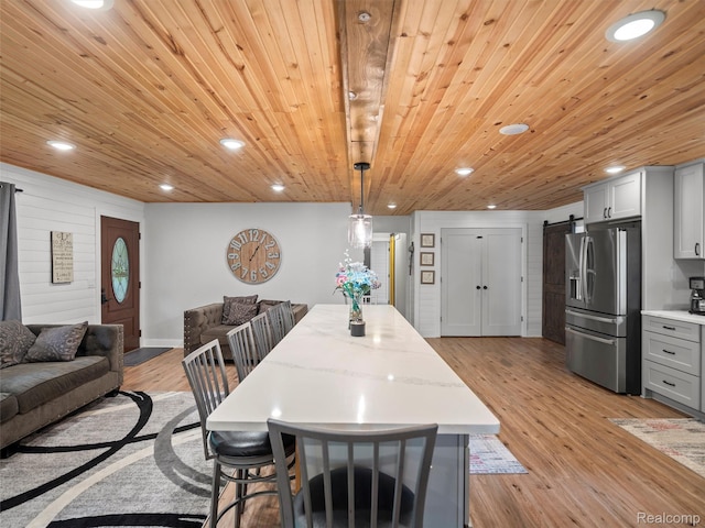 3365 Howland Rd, Almont, MI 48003 - dining area featuring a barn door, recessed lighting, wooden ceiling, and light wood-style floors