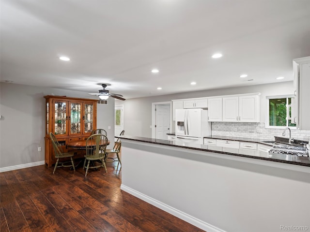 3365 Howland Rd, Almont, MI 48003 - kitchen with white refrigerator with ice dispenser, dark wood-type flooring, white cabinets, recessed lighting, and dark stone counters