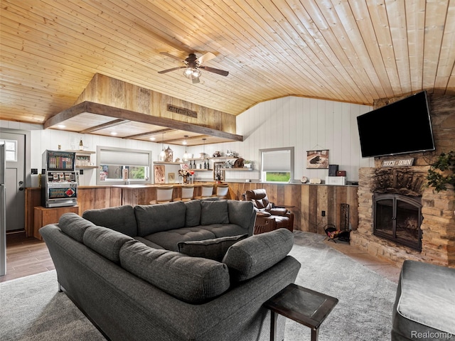 3365 Howland Rd, Almont, MI 48003 - living area with wood ceiling, vaulted ceiling, plenty of natural light, ceiling fan, and a stone fireplace