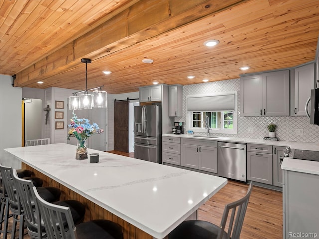 3365 Howland Rd, Almont, MI 48003 - kitchen with stainless steel appliances, gray cabinetry, wooden ceiling, light wood finished floors, and a barn door