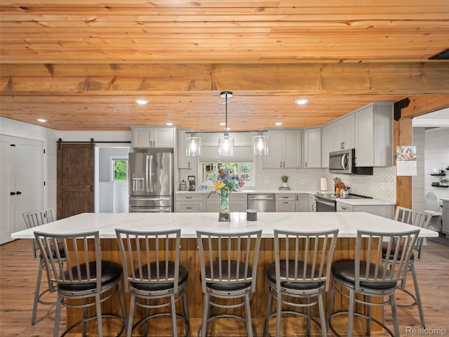 3365 Howland Rd, Almont, MI 48003 - kitchen featuring stainless steel appliances, wood finished floors, a barn door, gray cabinets, and wooden ceiling