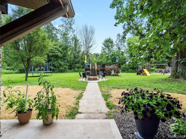 3365 Howland Rd, Almont, MI 48003 - view of green lawn with a trampoline, a playground, a patio area, and view of scattered trees