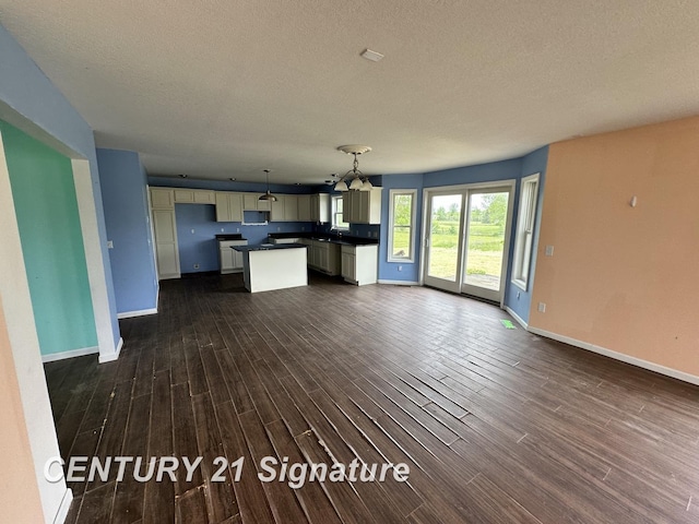 7265 Deweigan Ln, Mount Pleasant, MI 48858 - unfurnished living room featuring dark wood-style flooring, a textured ceiling, and a chandelier