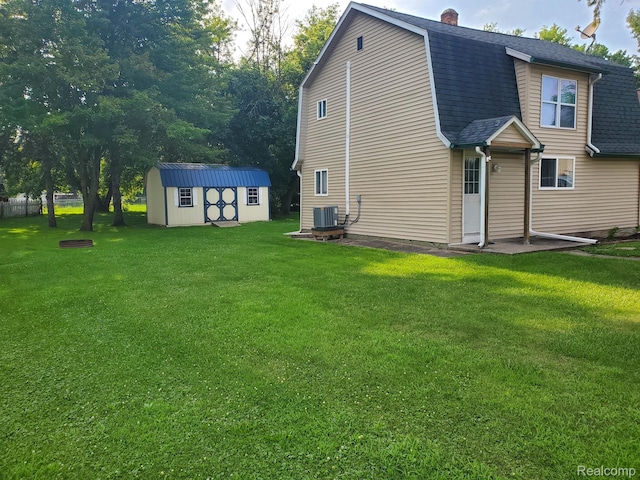 244 S Sherman St, Vassar, MI 48768 - back of house featuring a gambrel roof, a yard, a shed, roof with shingles, and a chimney