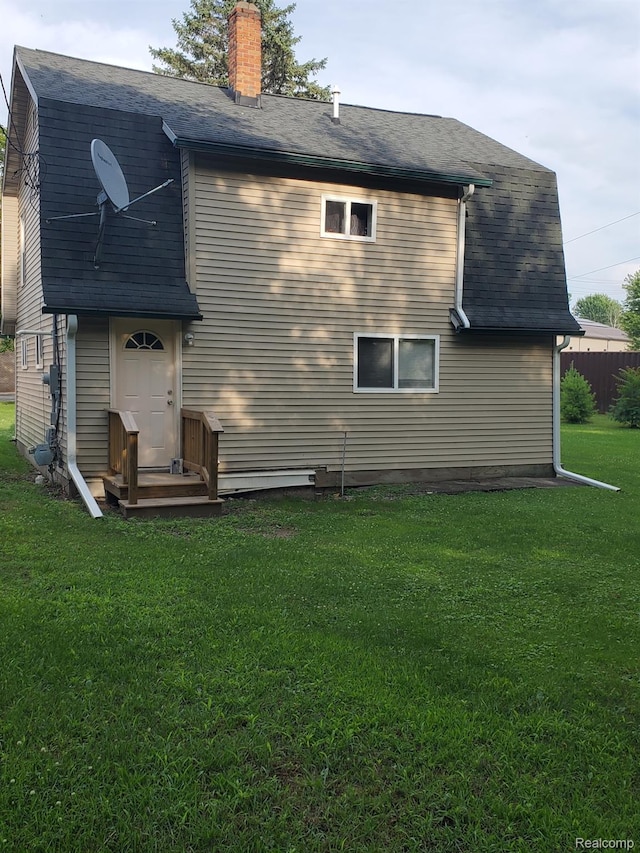 244 S Sherman St, Vassar, MI 48768 - rear view of house featuring a lawn and a chimney