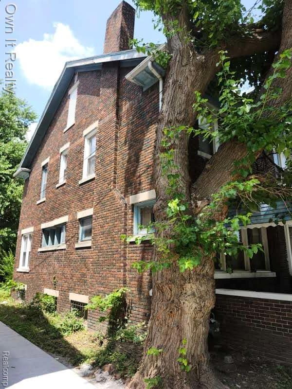 1950 Lawrence St, Detroit, MI 48206 - view of side of home with brick siding and a chimney