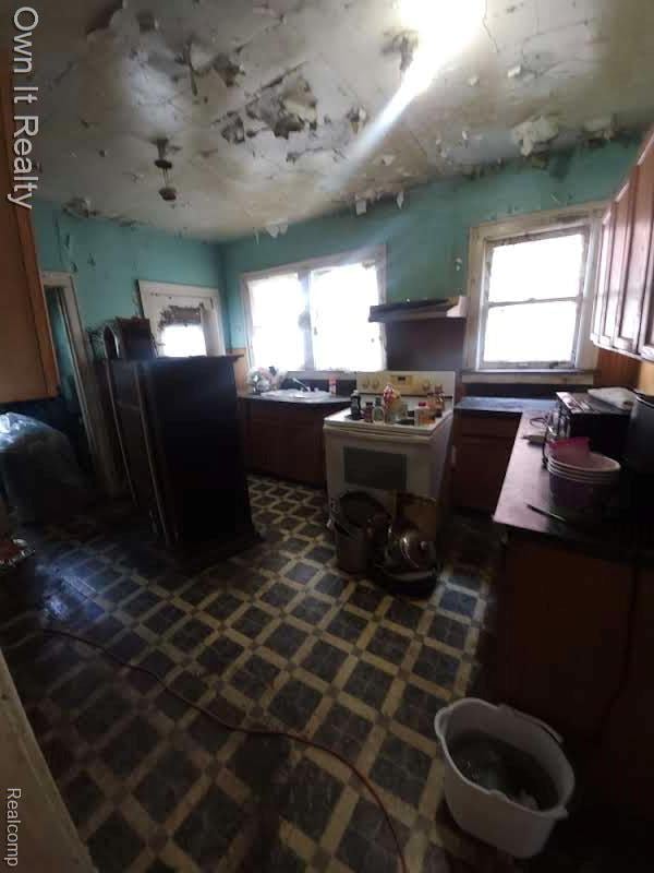 1950 Lawrence St, Detroit, MI 48206 - kitchen with white electric stove and brown cabinetry