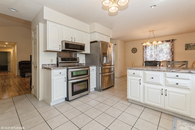 4175 Schmuhl Rd, Coloma, MI 49038 - kitchen featuring stainless steel appliances, a chandelier, light tile patterned flooring, white cabinets, and decorative light fixtures