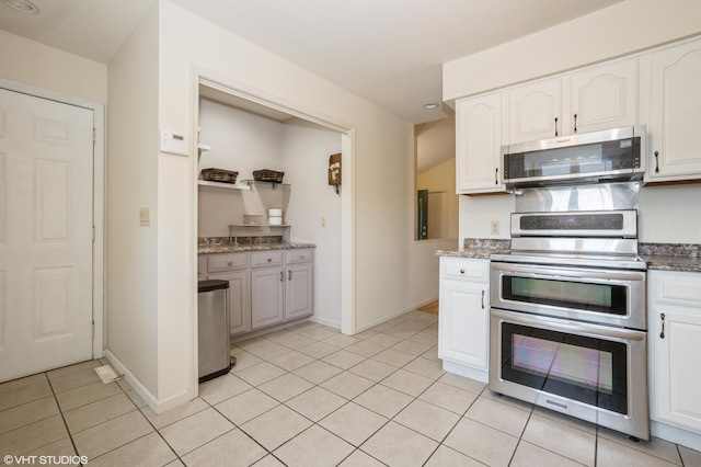 4175 Schmuhl Rd, Coloma, MI 49038 - kitchen with appliances with stainless steel finishes, white cabinets, light tile patterned flooring, and stone counters