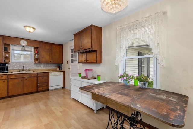 3116 E Apple Ave, Muskegon, MI 49442 - kitchen with white dishwasher, open shelves, light wood-style floors, brown cabinets, and tasteful backsplash