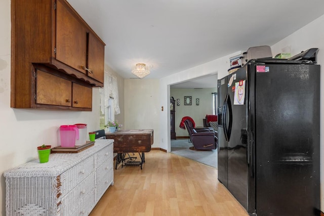 3116 E Apple Ave, Muskegon, MI 49442 - kitchen with black fridge, light wood-style floors, brown cabinetry, and light countertops