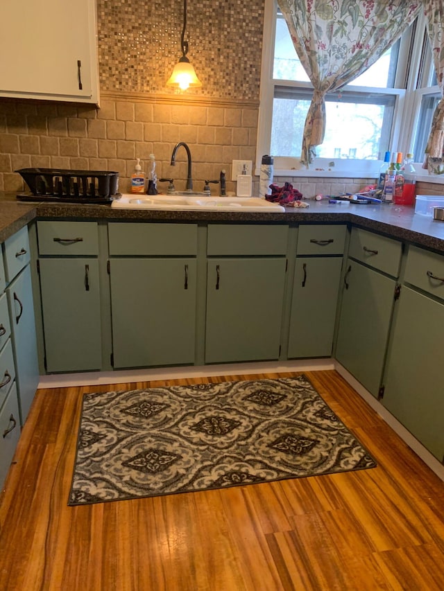 512 Green St, Dowagiac, MI 49047 - kitchen with decorative backsplash, wood finished floors, green cabinetry, and dark countertops