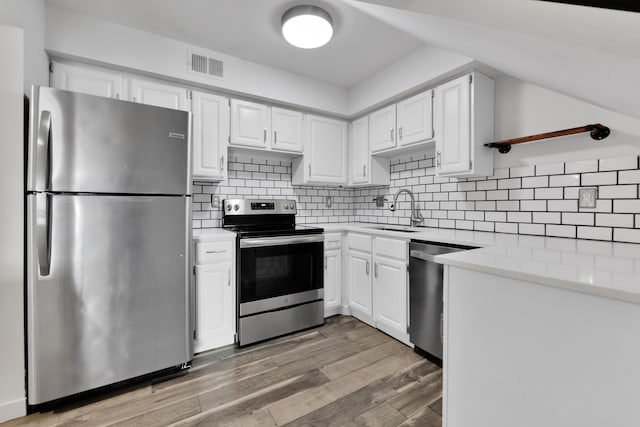 221 Pinewood Cir, Plymouth, MI 48170 - kitchen featuring appliances with stainless steel finishes, light wood-type flooring, light countertops, white cabinets, and backsplash