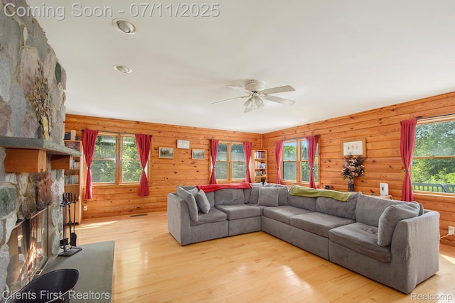 16501 Winters Rd, Grass Lake, MI 49240 - living room featuring ceiling fan, light wood finished floors, a fireplace, and wood walls
