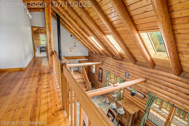 16501 Winters Rd, Grass Lake, MI 49240 - hall with a skylight, an upstairs landing, wooden ceiling, hardwood / wood-style floors, and log walls