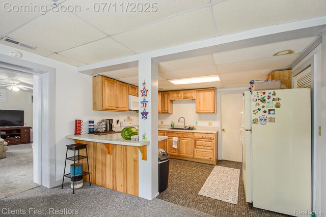 16501 Winters Rd, Grass Lake, MI 49240 - kitchen featuring white appliances, a drop ceiling, light countertops, dark carpet, and a breakfast bar area