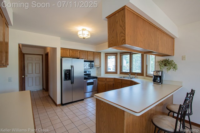 48600 Meadowcrest Dr, Macomb, MI 48044 - kitchen featuring appliances with stainless steel finishes, a peninsula, light countertops, light tile patterned floors, and brown cabinets