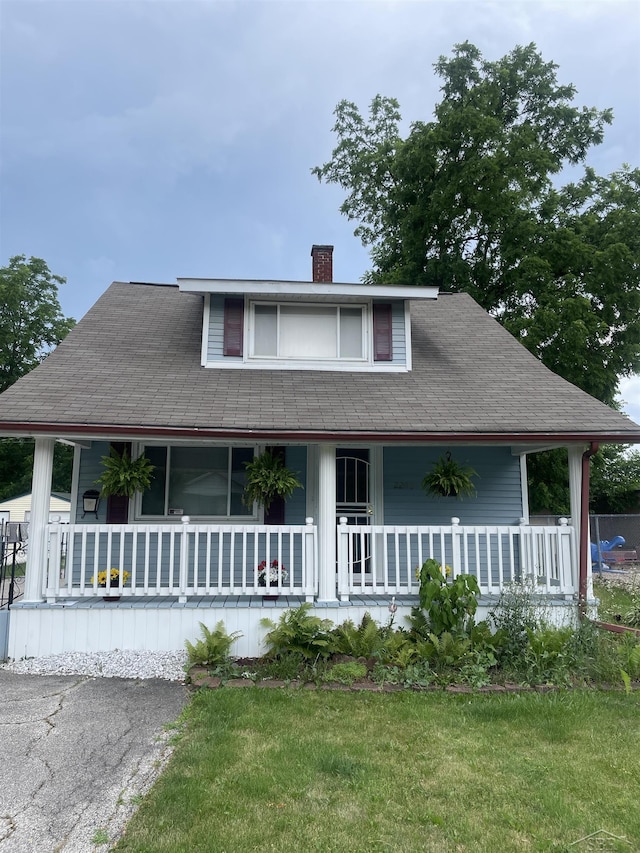 2205 Owen St, Saginaw, MI 48601 - farmhouse with a porch, a chimney, and a front yard