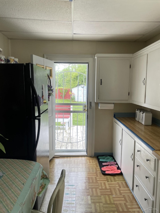 2205 Owen St, Saginaw, MI 48601 - kitchen with freestanding refrigerator and white cabinetry