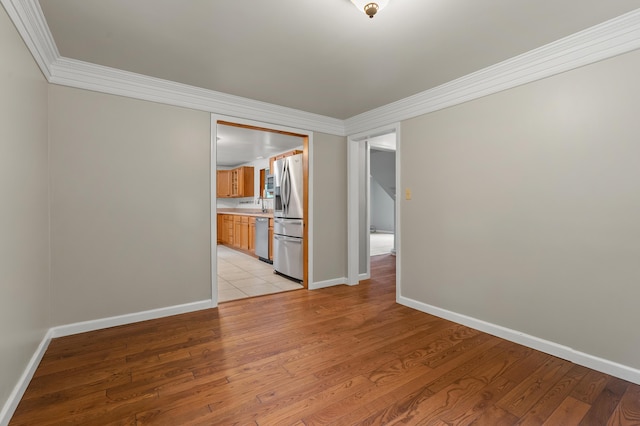 1402 Gracel St, Jackson, MI 49202 - unfurnished room featuring ornamental molding and light wood-style floors