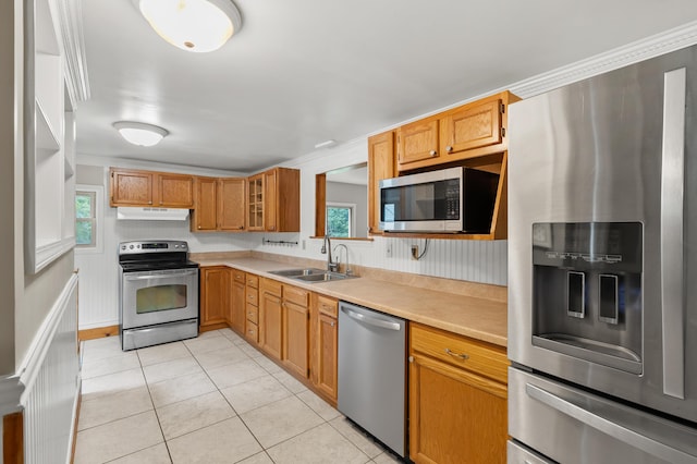 1402 Gracel St, Jackson, MI 49202 - kitchen featuring appliances with stainless steel finishes, under cabinet range hood, light countertops, light tile patterned floors, and glass insert cabinets