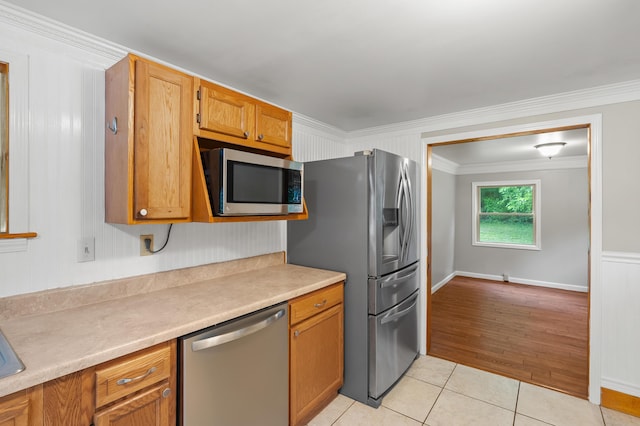 1402 Gracel St, Jackson, MI 49202 - kitchen with stainless steel appliances, crown molding, light tile patterned floors, light countertops, and brown cabinetry