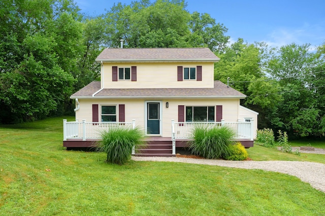1402 Gracel St, Jackson, MI 49202 - traditional-style house with a wooden deck, a front yard, and view of wooded area