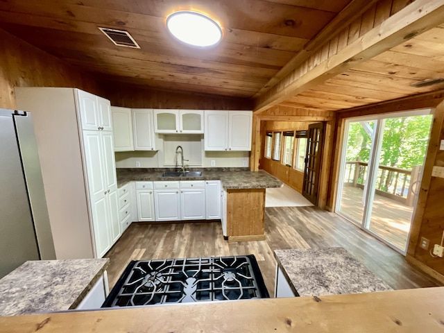 18572 Oxbow Dr, Barryton, MI 49305 - kitchen with wooden ceiling, white cabinetry, wooden walls, wood finished floors, and dark countertops