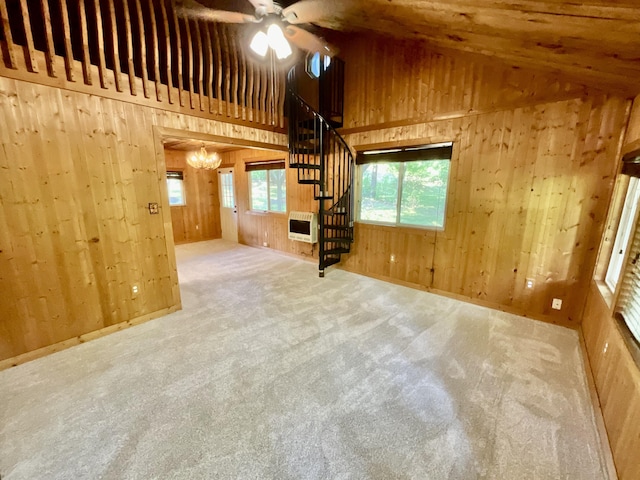 18572 Oxbow Dr, Barryton, MI 49305 - unfurnished living room featuring wood walls, carpet flooring, stairway, a chandelier, and ceiling fan