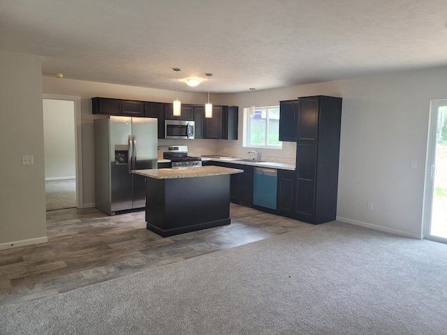 36 S Yankee Springs Rd, Middleville, MI 49333 - kitchen with stainless steel appliances, a kitchen island, dark carpet, and hanging light fixtures