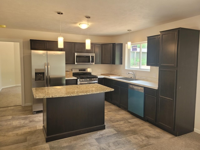 36 S Yankee Springs Rd, Middleville, MI 49333 - kitchen featuring appliances with stainless steel finishes, a center island, light wood-style floors, light stone counters, and hanging light fixtures