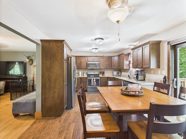 193 Miller Lake Rd, Columbiaville, MI 48421 - kitchen with stainless steel appliances, light wood-type flooring, and dark brown cabinets
