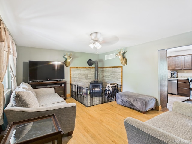 193 Miller Lake Rd, Columbiaville, MI 48421 - living area with a wood stove, a ceiling fan, and light wood-style floors