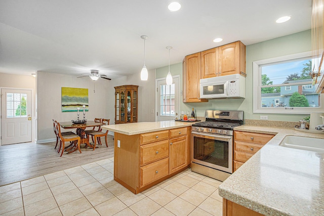 256 Nichols Dr, Saline, MI 48176 - kitchen featuring gas range, white microwave, a peninsula, light countertops, and healthy amount of natural light