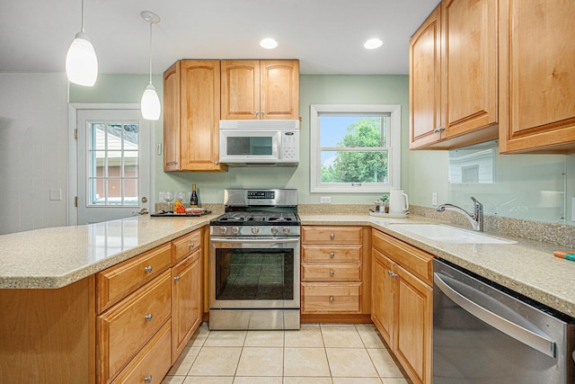 256 Nichols Dr, Saline, MI 48176 - kitchen with appliances with stainless steel finishes, a peninsula, light countertops, light tile patterned floors, and hanging light fixtures