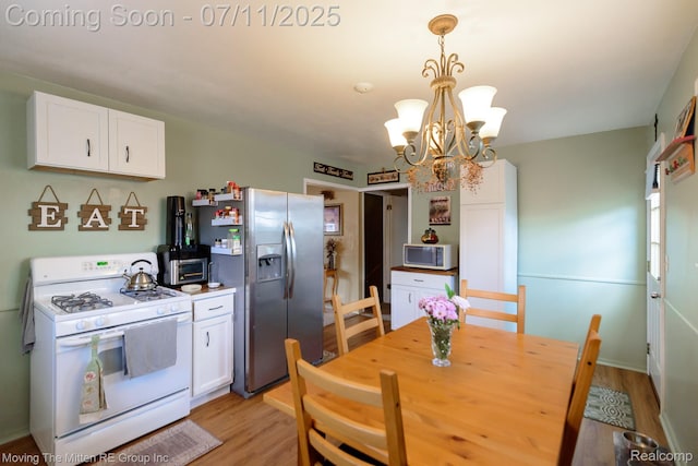 13620 Aston St, Romulus, MI 48174 - kitchen featuring white appliances, white cabinets, a chandelier, and light wood finished floors