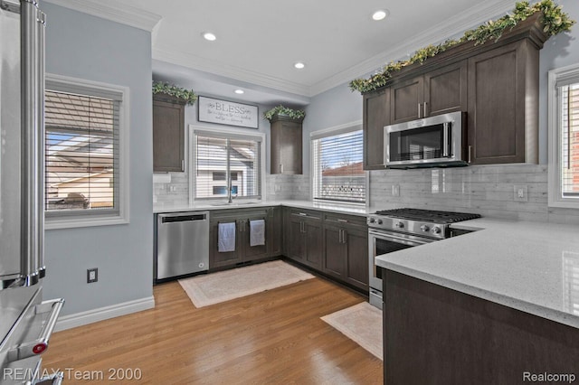 22543 E 11 Mile Rd, Saint Clair Shores, MI 48081 - kitchen featuring stainless steel appliances, dark brown cabinetry, light wood finished floors, crown molding, and backsplash