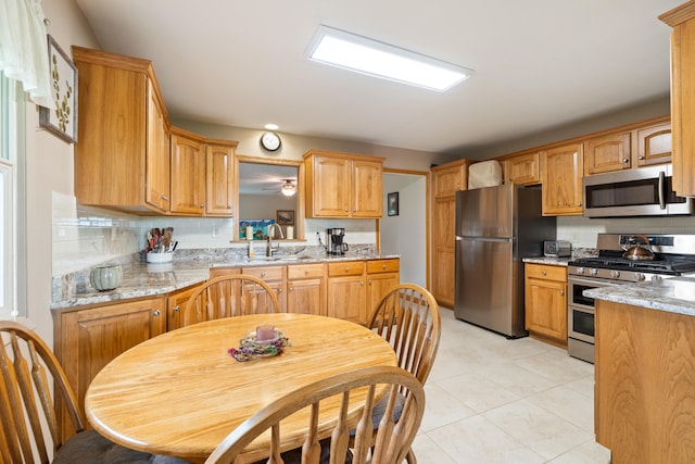 2230 Oleary Rd, Jackson, MI 49201 - kitchen with appliances with stainless steel finishes, backsplash, light tile patterned flooring, and light stone counters