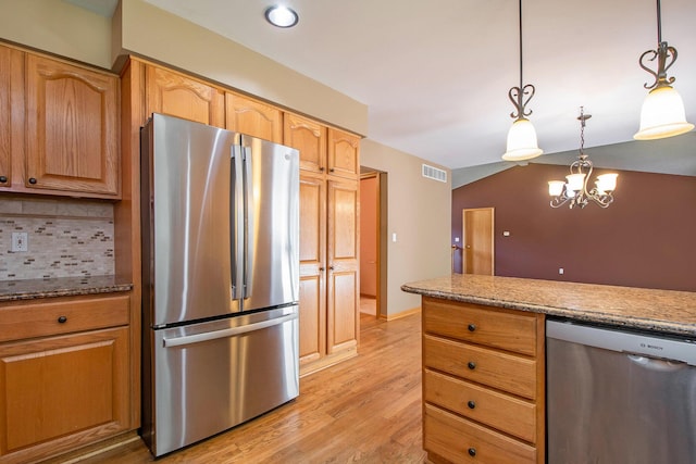 4291 Bramblewood Ct, Dorr, MI 49323 - kitchen featuring stainless steel appliances, light wood-type flooring, light stone countertops, decorative light fixtures, and backsplash