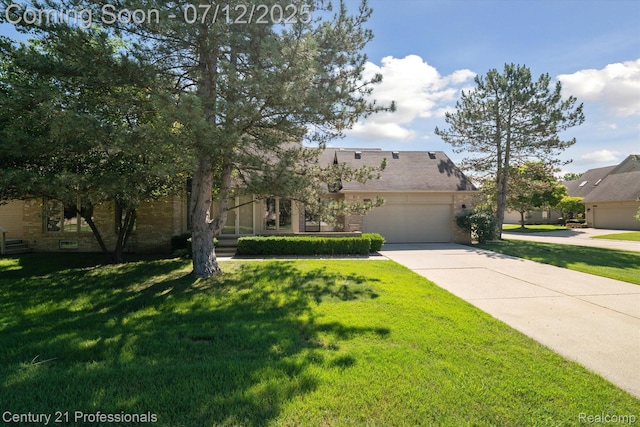 17012 Coral Ln, Macomb, MI 48042 - view of front facade with concrete driveway, brick siding, a front lawn, and an attached garage