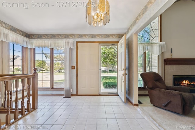 17012 Coral Ln, Macomb, MI 48042 - foyer featuring light tile patterned floors, a chandelier, a tiled fireplace, and wallpapered walls